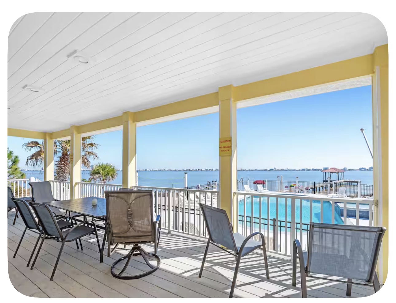 Covered porch dining area overlooking the pool and lagoon